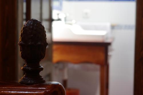 a statue sitting on a wooden chair in front of a desk at Casa El Pilpayu in poo de Llanes