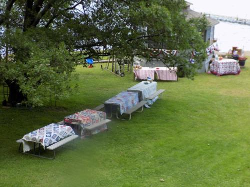 a group of picnic tables in a grass field at StoneWall House in Lake Elmo