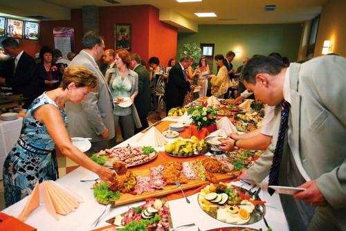 a group of people standing around a table of food at Wellness Hotel Bešeňová in Bešeňová