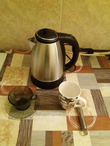 a tea kettle and two cups on a table at Centre two bedrooms apartment in Podgorica