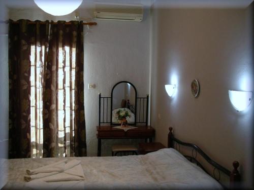 a bedroom with a bed and a table and a mirror at Atlantis Hotel in Myrties
