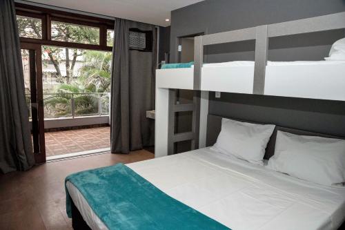 a bedroom with two bunk beds and a balcony at REF House Barra Da Tijuca in Rio de Janeiro