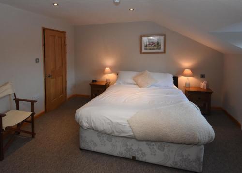 West DownにあるThe Crown Innのベッドルーム(白い大型ベッド、ランプ2つ付)