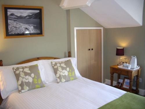 1 dormitorio con 1 cama y 1 mesa con teléfono en Lingmoor, en Windermere
