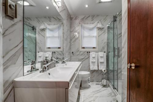 a white bathroom with a sink and a shower at Vineyard Villa in Niagara on the Lake