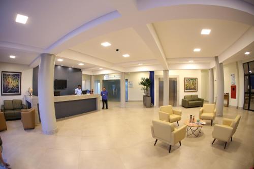 um lobby de um hospital com cadeiras e um balcão em Real Praia Hotel em Aracaju