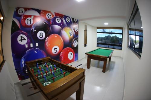 a room with a pool table and a wall of balls at Real Praia Hotel in Aracaju