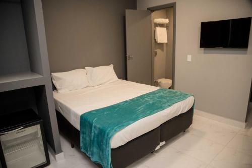 a bedroom with a bed with a blue blanket on it at REF House Barra Da Tijuca in Rio de Janeiro