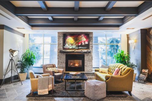 a living room filled with furniture and a fire place at Summit Lodge Boutique Hotel Whistler in Whistler