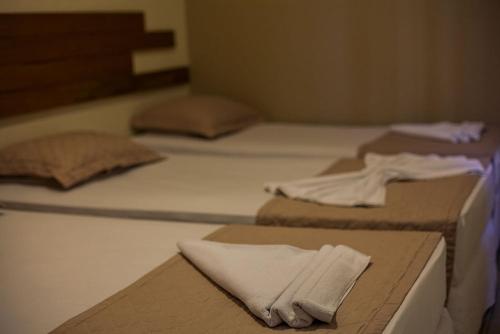 a group of three beds in a room at Portal Da Praia Hotel in Fortaleza