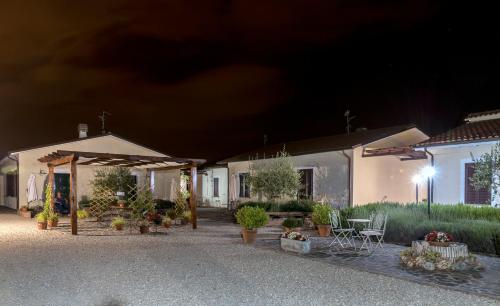 a group of houses at night with plants and tables at Residence Terra Dei Santi Country House in Spello