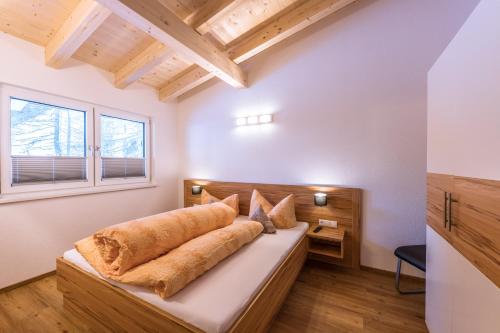 Łóżko w pokoju z drewnianym sufitem w obiekcie Gästehaus Runhof w Langenfeld