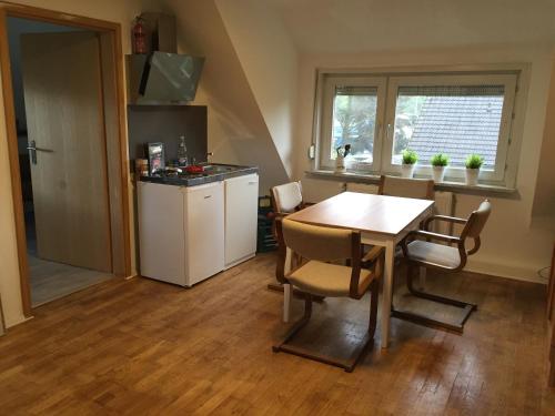 eine Küche mit einem Tisch und Stühlen sowie eine Küche mit einer Theke in der Unterkunft Casa Verde Kassel in Kassel