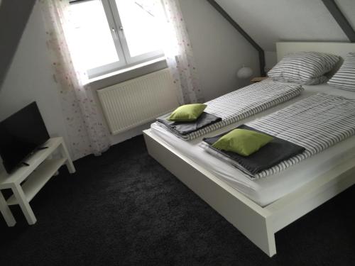 a bedroom with a bed with two pillows and a window at Casa Verde Kassel in Kassel