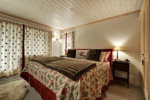 ein Schlafzimmer mit einem Bett und einem Tisch mit einer Lampe in der Unterkunft Chalet Drusa in Klosters Serneus