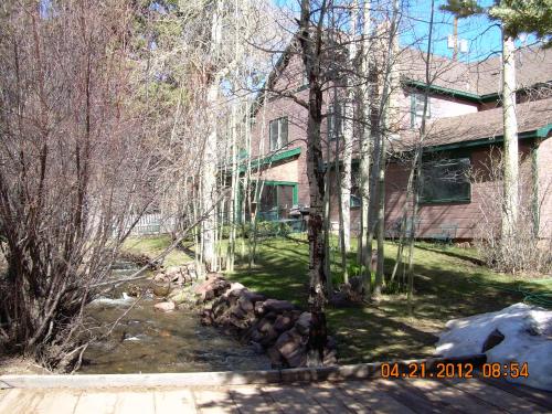 a house with a pile of logs in the yard at Dodgeton Creek Inn in Cuchara
