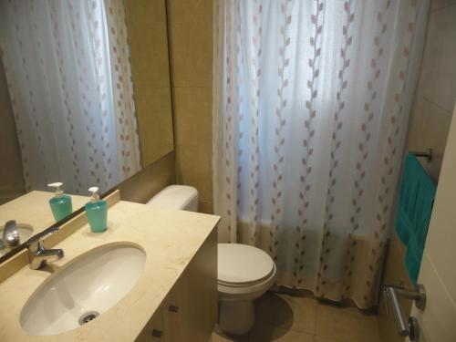 a bathroom with a white sink and a toilet at Laura Barros, Con Con in Concón