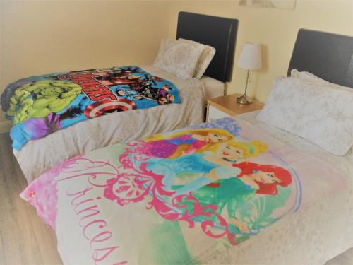 a bedroom with two beds with a mermaid blanket at GlenHaven Holiday Accommodation in Glenariff