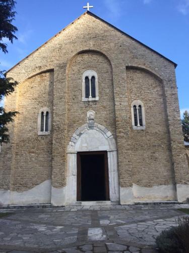 an old brick church with a door and a cross at Prenociste DM5 in Novi Pazar