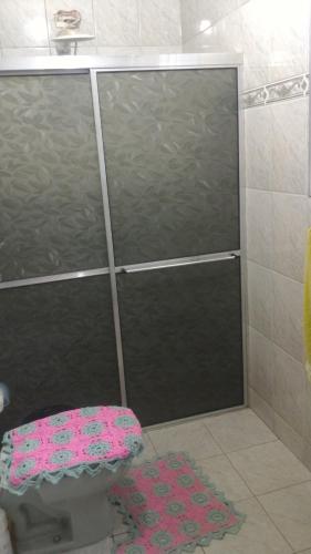 La salle de bains est pourvue d'une douche avec une porte en verre. dans l'établissement Nossa Casa, à Cunha