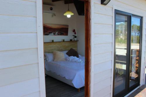 Cette chambre comprend un lit et une porte coulissante en verre. dans l'établissement Imaginate, à Punta del Este