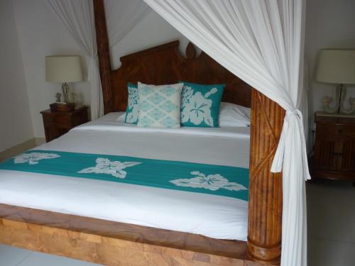 1 dormitorio con 1 cama con dosel en Taman Sari Villas, en Seminyak