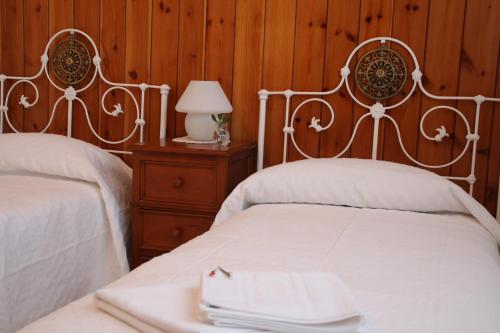a bedroom with two beds and a table with a lamp at El jardín de la abuela in Granada