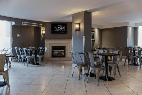 a dining room with tables and chairs and a fireplace at Hotel Faubourg Montreal Centre-Ville Downtown in Montréal