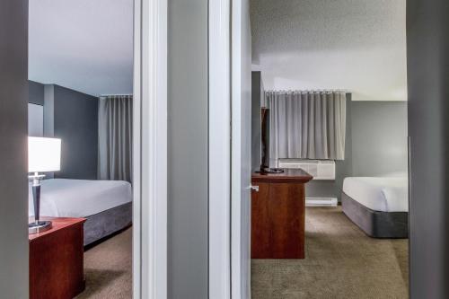 Cette chambre comprend deux lits et une télévision. dans l'établissement Hotel Faubourg Montreal Centre-Ville Downtown, à Montréal
