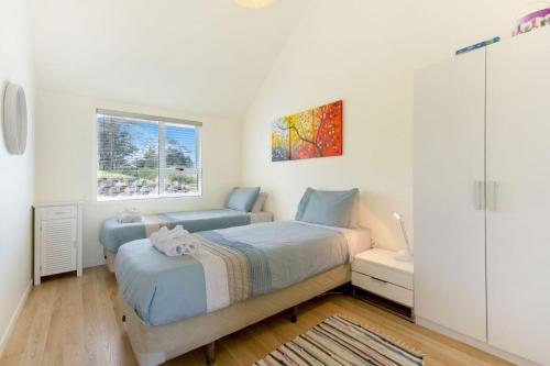 a bedroom with a bed and a window at The Apartment at Palm Beach by Waiheke Unlimited in Palm Beach