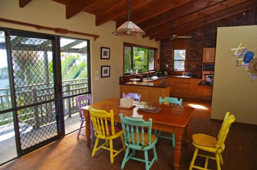 a kitchen and dining room with a wooden table and chairs at LaMaison de Shines, 13 Dulconghi Street in Crescent Head