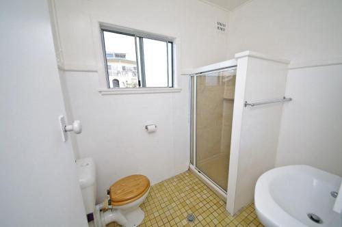 a bathroom with a shower and a toilet and a sink at Apollo 1, 9 Hodgson Street in Crescent Head