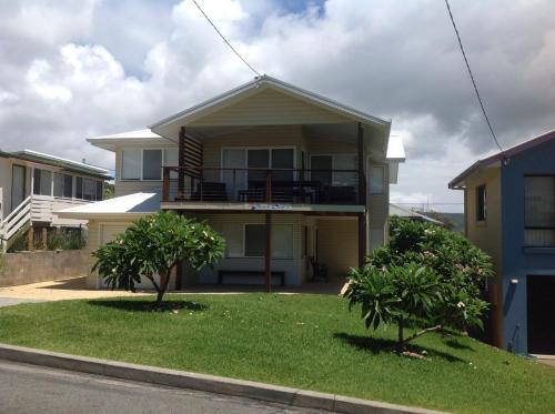 a house with a balcony and two trees in the yard at Beach Club 1, 5 Gowing Street in Crescent Head