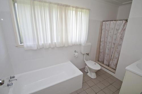 biała łazienka z toaletą i prysznicem w obiekcie Billy's on Main, 44 Main Street w mieście Crescent Head