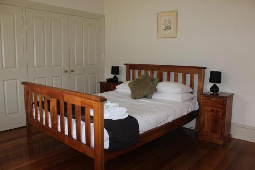 a bedroom with a wooden bed with white sheets and pillows at 20 Mountbatten Ave, Bright in Bright
