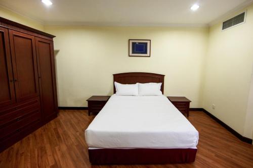 a bedroom with a large bed with white sheets at Beta Service Apartment in Labuan