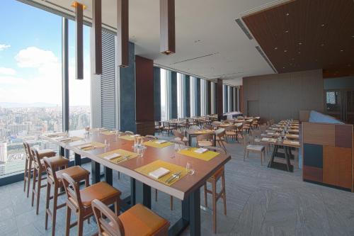 a dining room with tables and chairs and windows at Nagoya Prince Hotel Sky Tower in Nagoya