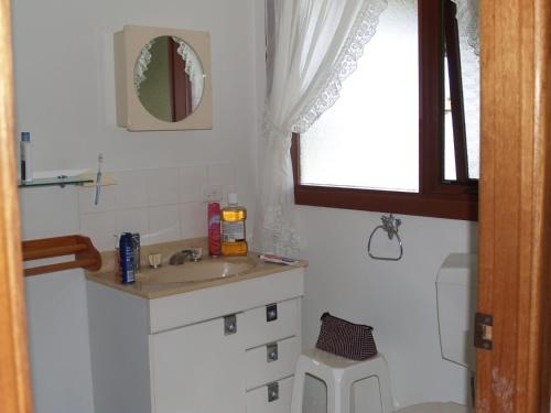 a small bathroom with a sink and a mirror at Rocky Beach Cottage 26 Pacific Drive in Port Macquarie