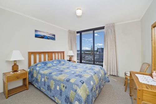 a bedroom with a bed and a desk and a window at Sundial 602 8-10 Hollingworth Street in Port Macquarie