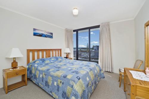una camera da letto con un letto, una scrivania e una finestra di Sundial 602 8-10 Hollingworth Street a Port Macquarie