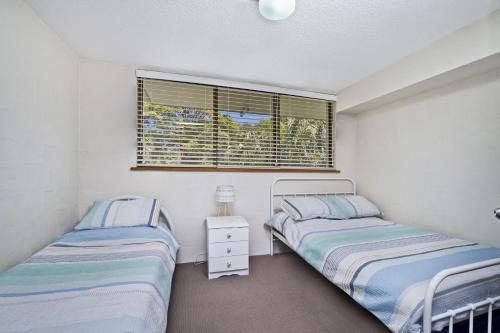 a bedroom with two beds and a window at Ocean Terrace 6 67 Pacific Drive in Port Macquarie
