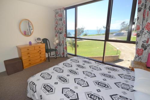 a bedroom with a bed and a large window at Beachpark 10 58 Pacific Drive in Port Macquarie