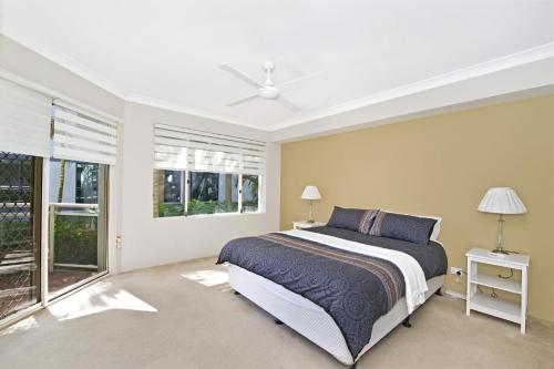 a bedroom with a bed and a large window at Westport Palms 14 Buller Street in Port Macquarie