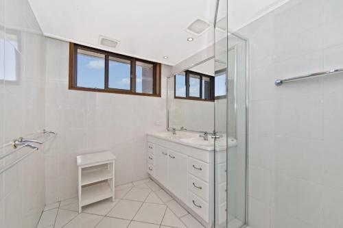 a white bathroom with a sink and a shower at Akuna 18 6 Joffre Street in Port Macquarie