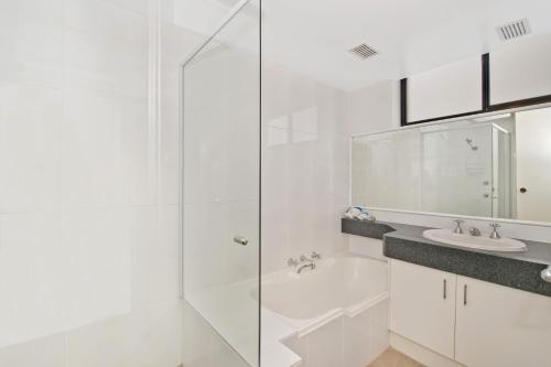 a white bathroom with a shower and a sink at Tasman Towers 9 3 Munster Street Port Macquarie in Port Macquarie
