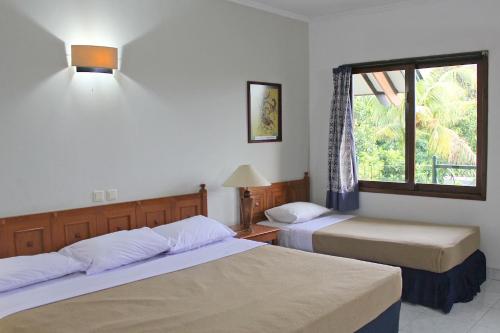 Tempat tidur dalam kamar di Hotel Winotosastro Garden