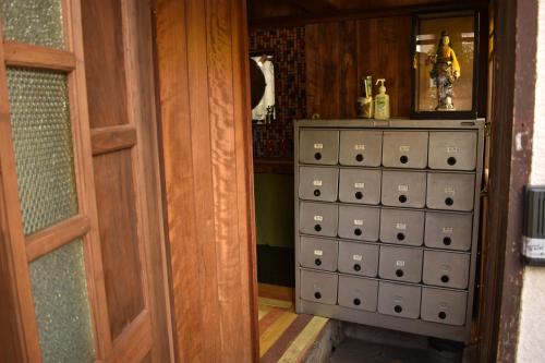 a room with a door and a cabinet with boxes at Villa Sacra in Kamakura