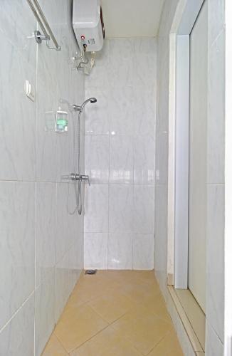 a bathroom with a shower with a glass door at Wika Bali Beach House in Jimbaran