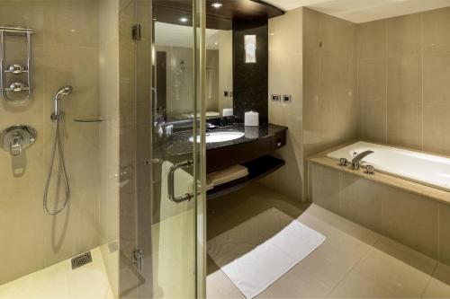 a bathroom with a shower and a sink and a tub at Grand Forward Hotel in Taipei