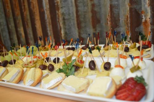 a plate of food with cheese and fruit on a table at Prince Of Wales Hotel Gulgong in Gulgong